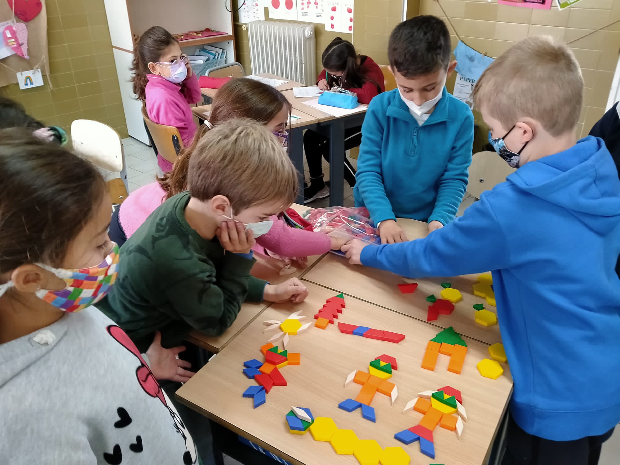 Nens i nenes manipulant materials per aprendre matemàtiques